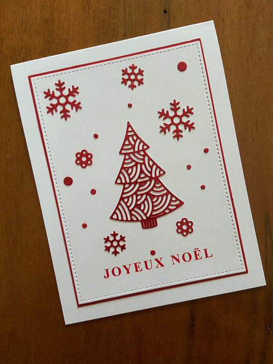 Handmade French Christmas card with a red ornate tree and snowflakes, and the text 'Joyeux Noël' on a white background.