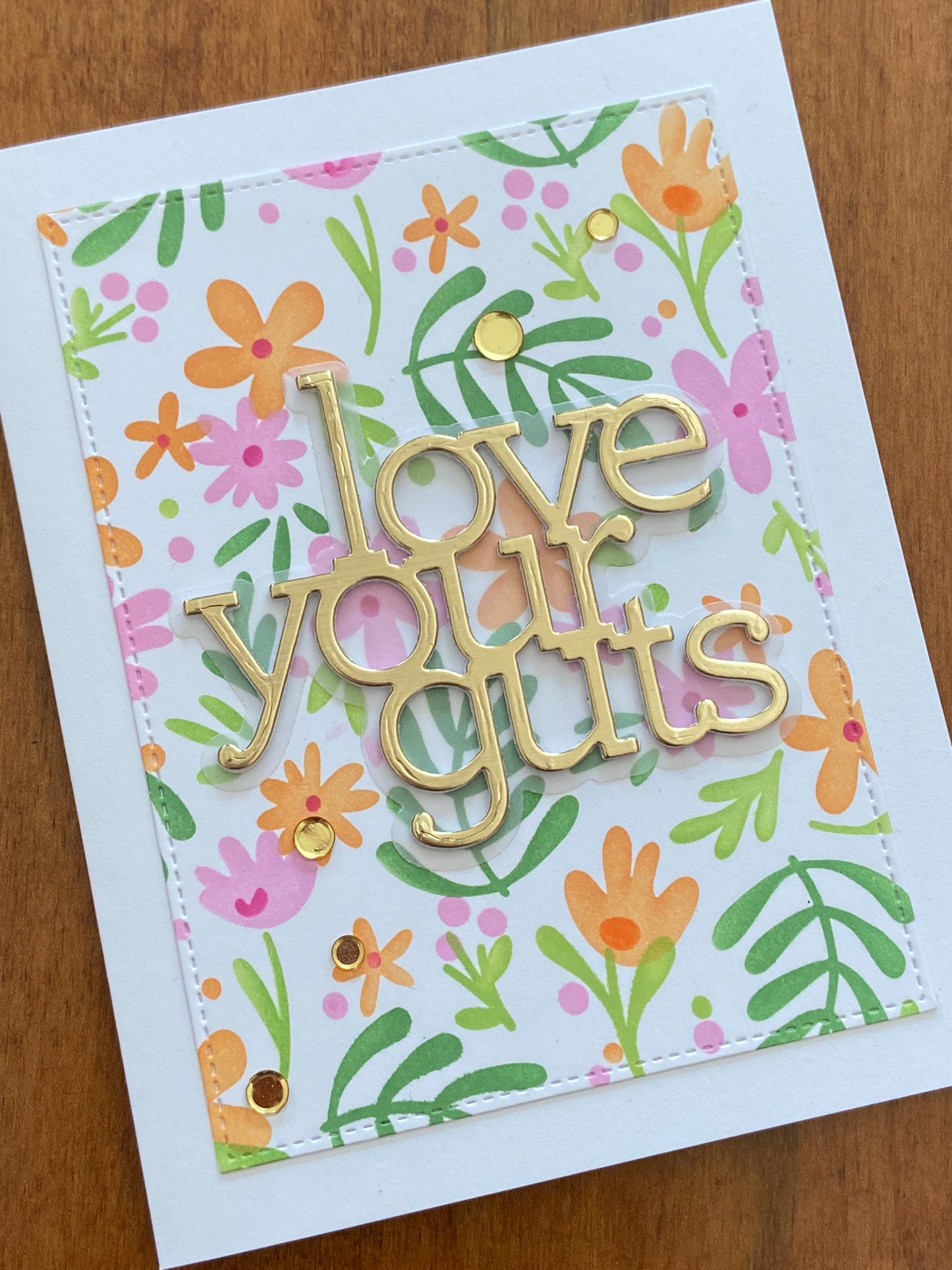 A fun love card with floral design and gold die cut text 'love your guts' on a white notecard