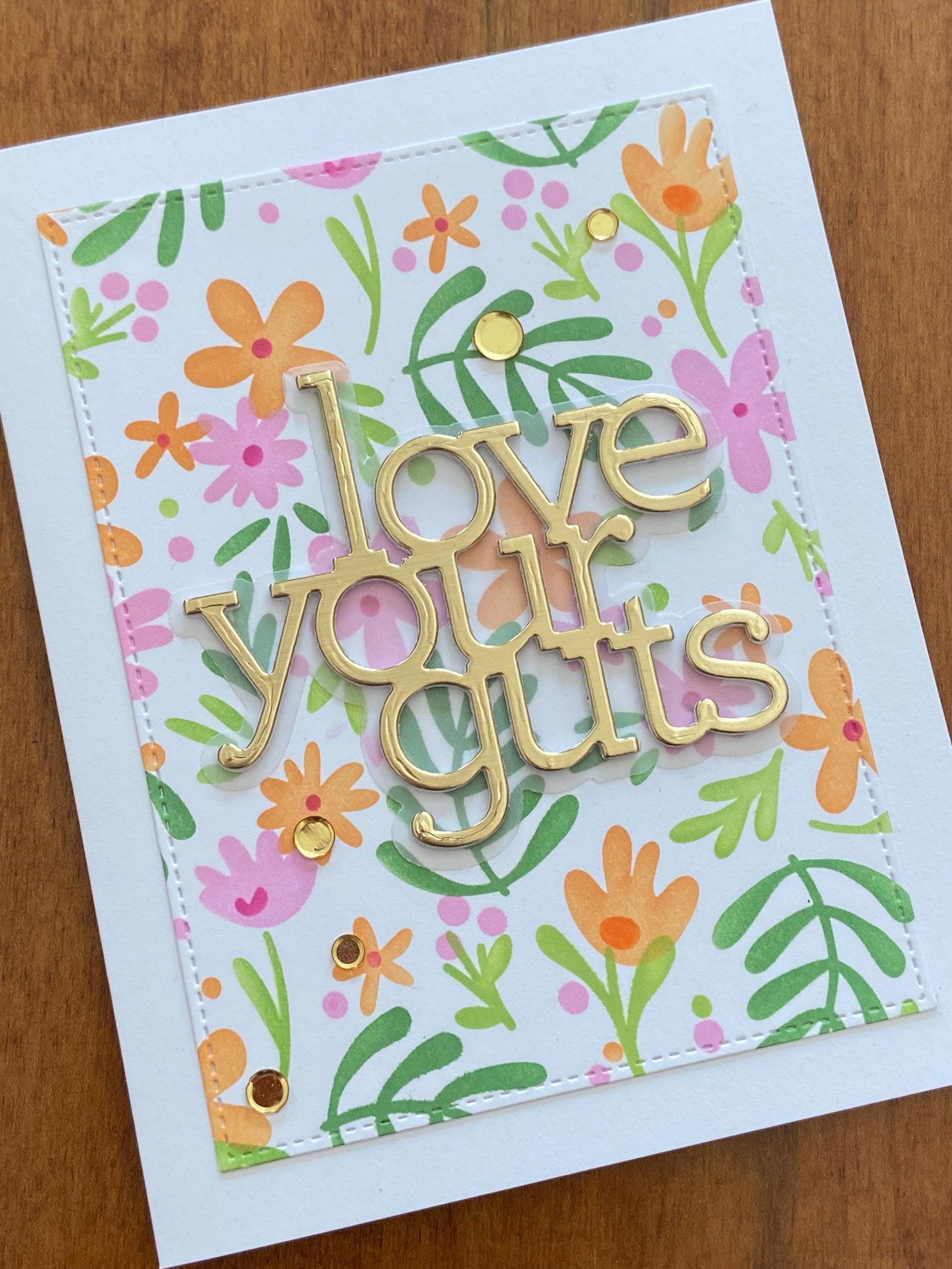 A fun love card with floral design and gold die cut text 'love your guts' on a white notecard