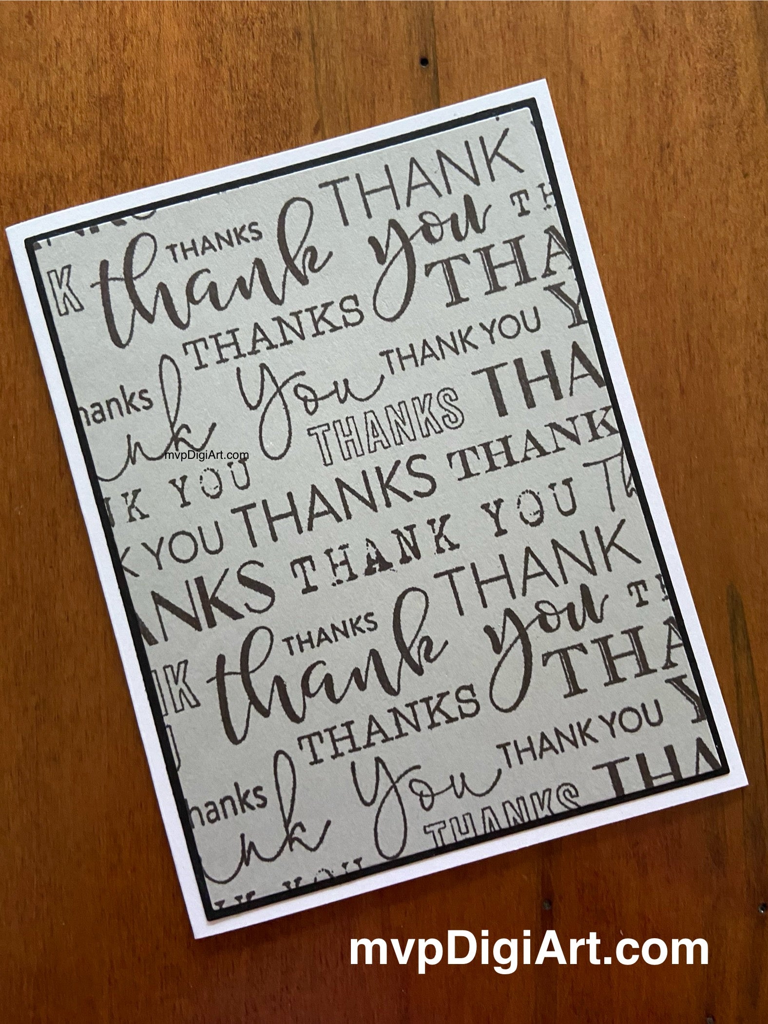 Front view of card 1 of the 2-pack handmade thank you cards showing thank you in a variety of fonts in grey plus layered panels with matte border