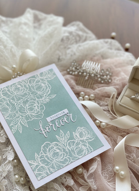 Handmade wedding card with 'Together Forever' sentiment and green accents displayed on decorated surface