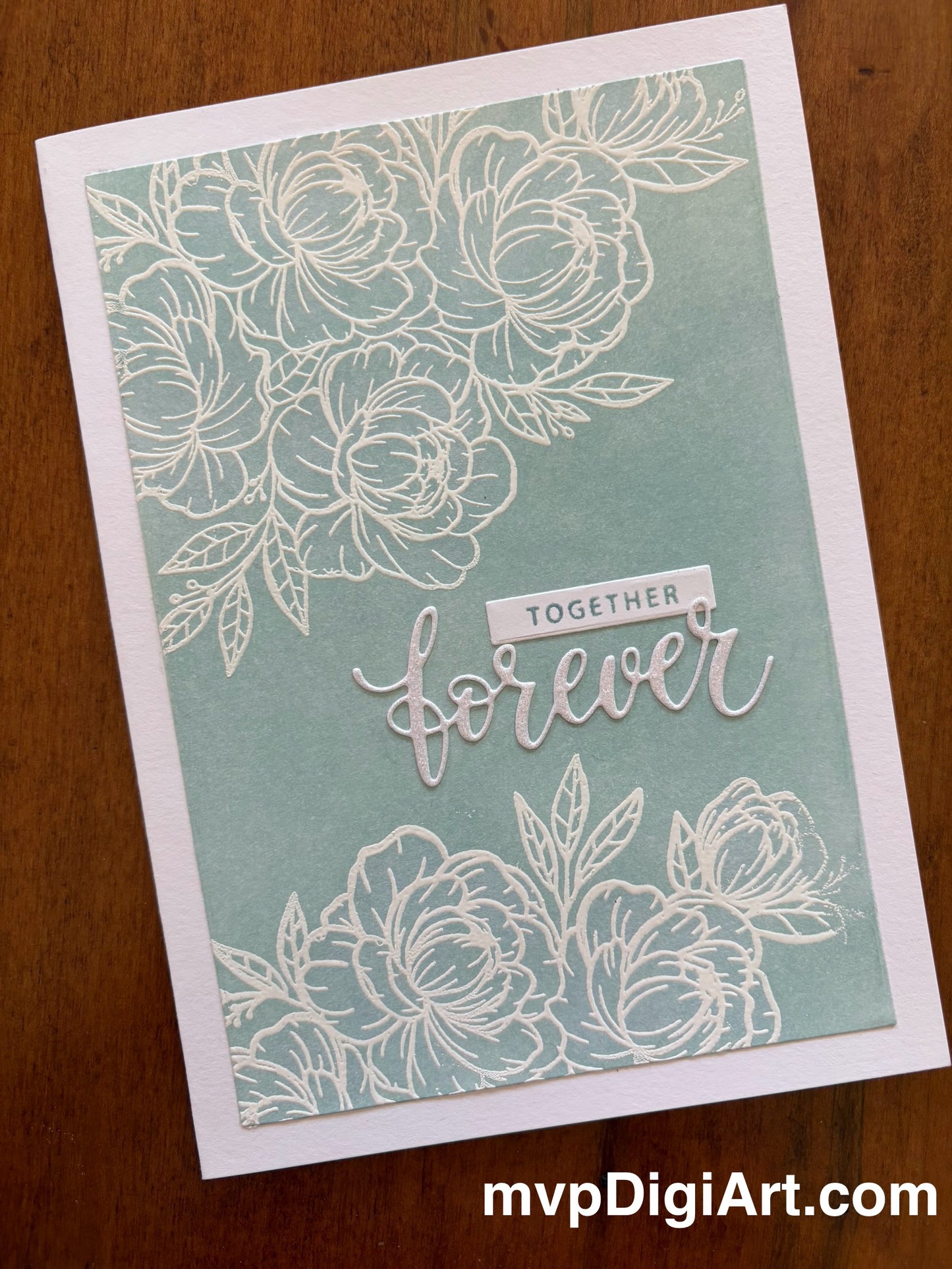 Handmade wedding card in a green blue colour with 'Together Forever' sentiment and and white floral outline design