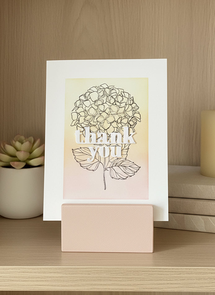 Handmade thank you card with pink orange yellow hydrangea design displayed on book shelf 