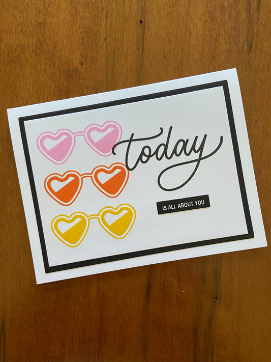 Today is all about you birthday or celebration handmade card. 3 heart shaped lens sunglasses are stamped in yellow, orange and pink on the left side. 