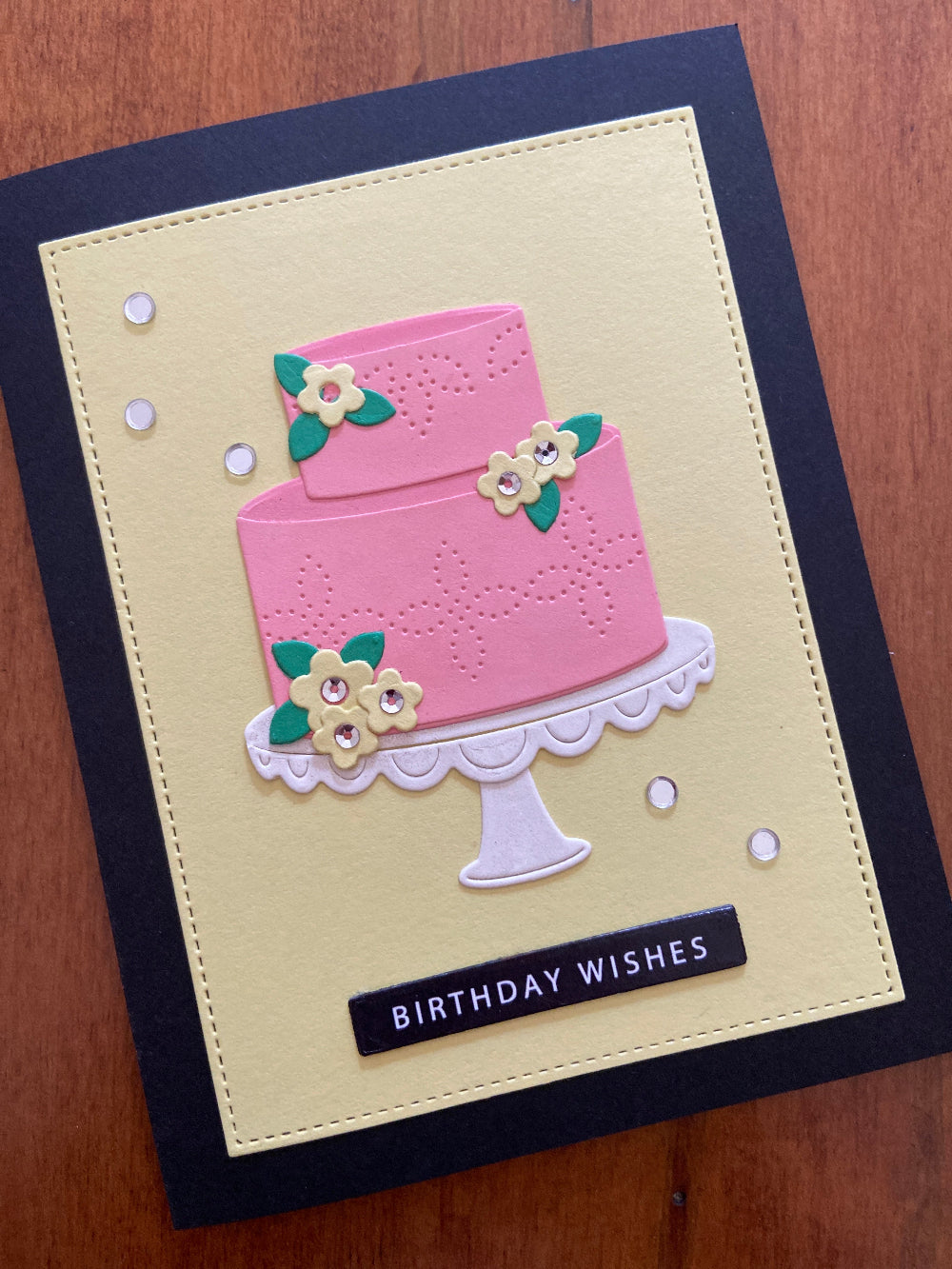 Handmade pink birthday cake card with tiered cake design, tiny flowers, Birthday Wishes sentiment, yellow panel and black base with silver embellishments