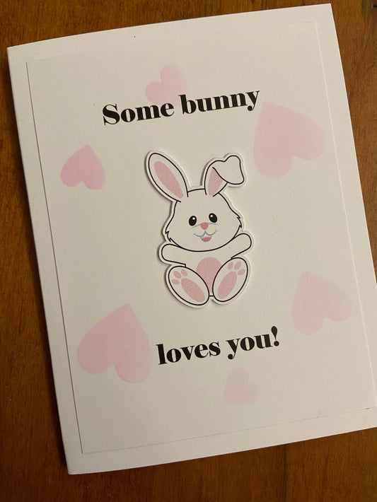 Handmade love card featuring an original illustrated bunny surrounded by blush pink hearts with the sentiment "Some Bunny Loves You!"