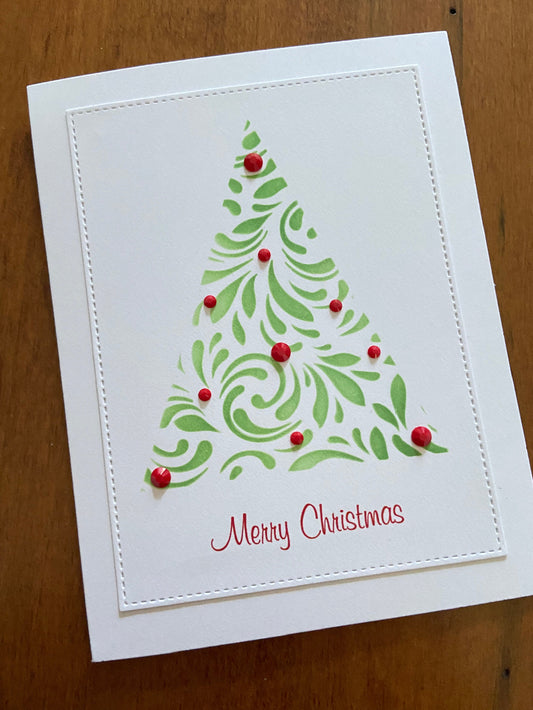 Handmade Christmas card with stylized evergreen tree decorated with ruby red gems, text ‘Merry Christmas’