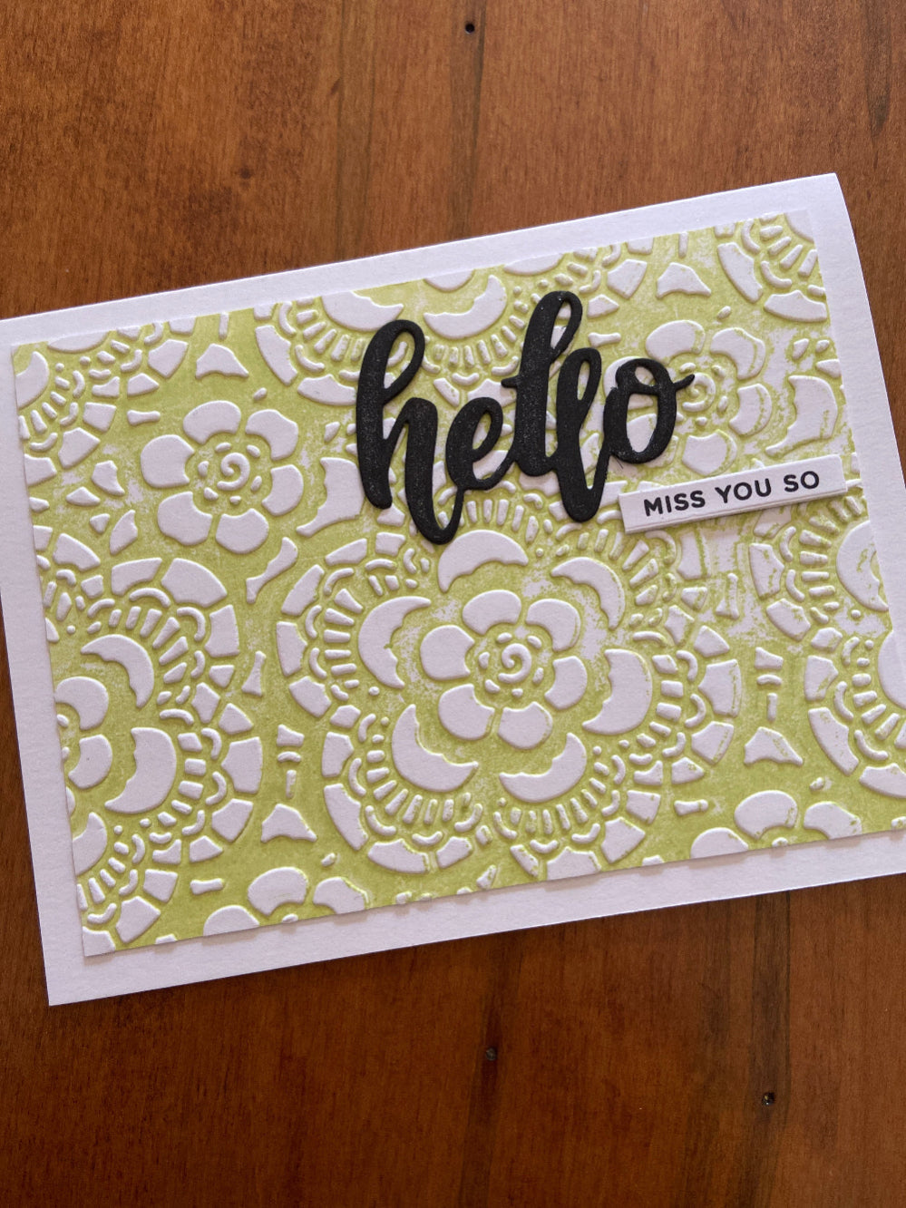 A textured Hello, miss you so card; green and white, floral embossed