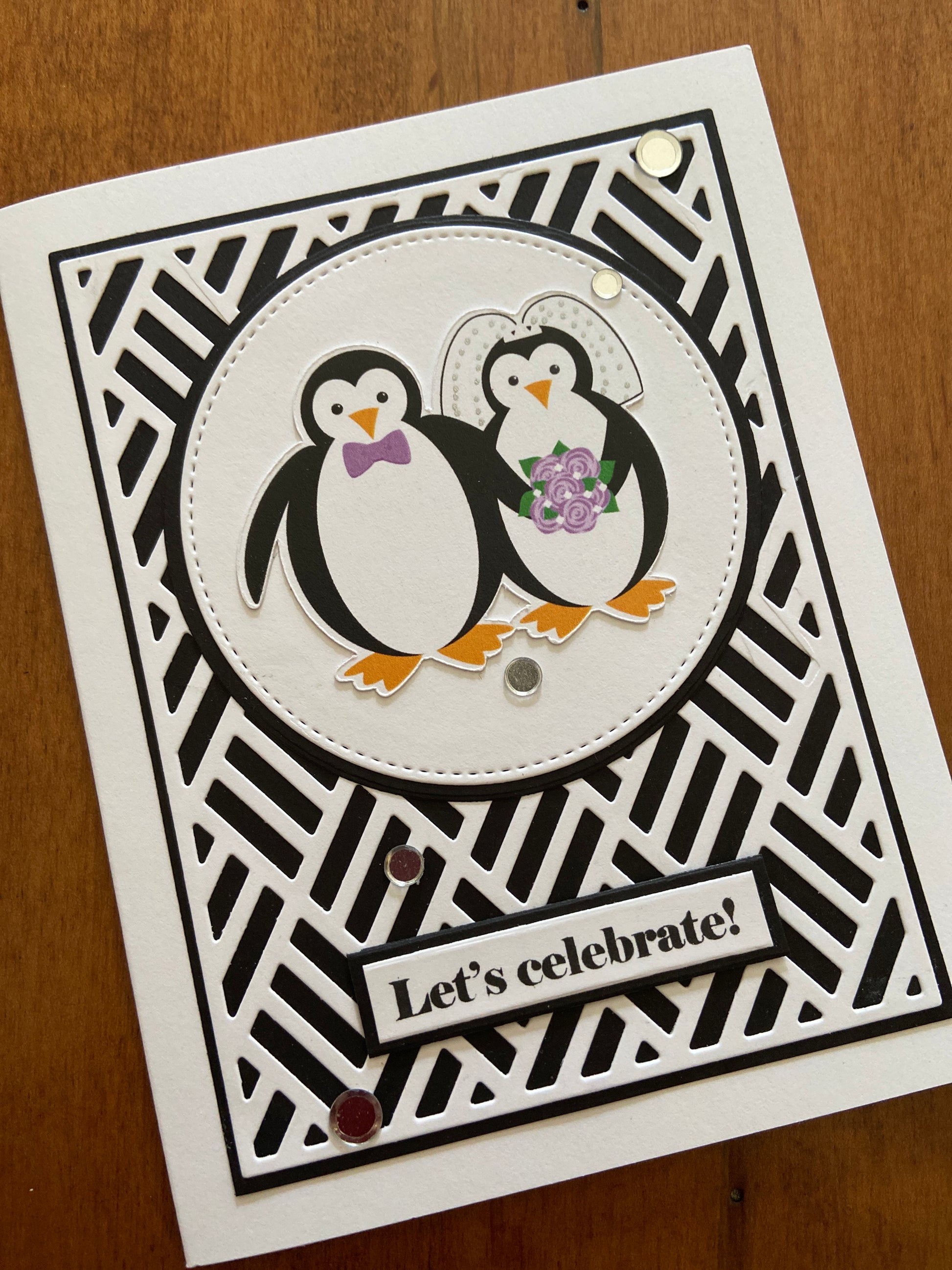 Bold and graphic wedding card with a white die cut basket-weave over black background. A cute penguin bride and groom as a focal point, a “let’s celebrate” sentiment strip with a little bling here and there for sparkle.